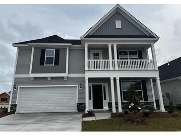 Two-story home with gray siding, white trim, a two-car garage and a covered porch at 4035 Bucolic Loop, Myrtle Beach, SC 29588