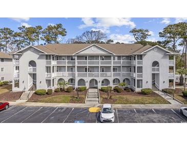 Exterior view of multi-story condo complex with well-maintained landscaping and parking at 4430 Eastport Blvd. # L5, Little River, SC 29566