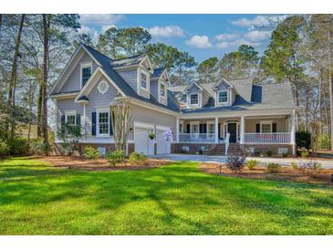 Charming home featuring dormers and a welcoming front porch, surrounded by lush landscaping at 4514 Wagon Run Circle, Murrells Inlet, SC 29576