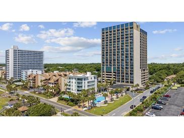 Stunning aerial view of a beachfront condo complex with a pool and surrounding palm trees at 5523 N Ocean Blvd. # 1101, Myrtle Beach, SC 29577