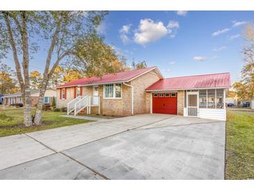 Charming brick home boasts a red roof, attached garage and welcoming screened porch, plus mature landscaping at 602 Luttie Rd., Myrtle Beach, SC 29588