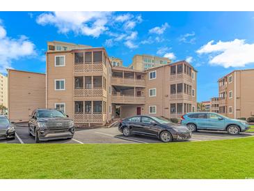 A charming tan condo building with parking and green space at 609 Hillside Dr. S. # E-18, North Myrtle Beach, SC 29582
