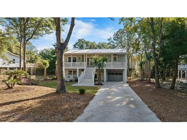 Inviting two-story home with a spacious driveway, elevated porch, and a convenient garage at 108 Cole Dr., Pawleys Island, SC 29585