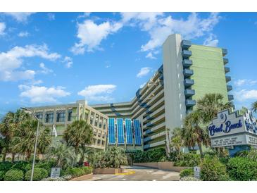 Wide shot of the Coral Beach Resort, showcasing its unique architecture and beautiful landscaping with many palm trees at 1105 S Ocean Blvd. # 446, Myrtle Beach, SC 29577