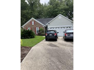 Charming single-story home featuring brick and siding exterior with well-maintained landscaping and a two car garage at 1372 Oakmont Ct., Murrells Inlet, SC 29576