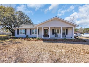 Charming single-story home with a welcoming front porch, rocking chairs, and well-maintained landscaping at 1751 Nichols Hwy., Aynor, SC 29511