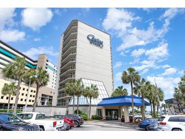 Lovely condo exterior with blue awning, palm trees and blue skies on a sunny day at 200 76Th Ave. N # 410, Myrtle Beach, SC 29572