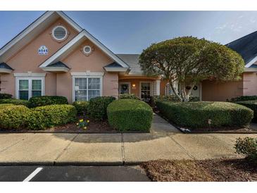 Charming home with manicured landscaping, inviting walkway, and peach stucco exterior at 4545 Lighthouse Dr. # 28C, Little River, SC 29566