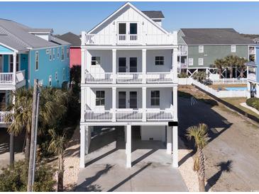 Stunning three-story beach house featuring multiple balconies, white facade, and raised foundation at 1211-B N Waccamaw Dr., Garden City Beach, SC 29576