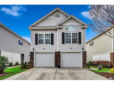 Charming two-story home featuring a symmetrical design with a two-car garage and neat front yard landscaping at 1411 Powhaton Dr., Myrtle Beach, SC 29577