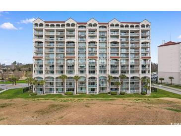 Large condo building featuring multiple floors, balconies, palm trees, and a well-maintained green space at 2151 Bridge View Ct. # 1-1103, North Myrtle Beach, SC 29582