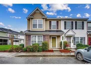 Two-story townhome with neutral siding, mulched beds and trimmed shrubs beneath a partly cloudy sky at 2720 Marengo Ln. # 2720, Conway, SC 29526