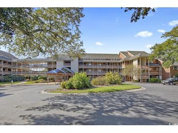 Charming condo complex featuring multiple levels, lush landscaping, and an inviting entrance at 410 Melrose Pl. # 308, Myrtle Beach, SC 29572