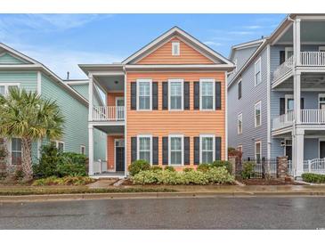 Charming, two-story home featuring a balcony, tidy landscaping, and colorful exterior at 7809 Monarch Dr., Myrtle Beach, SC 29572