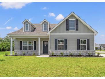 Charming single-Gathering home featuring a covered porch, dormer windows, and well-maintained landscaping at 127 Old Chimney Ln, Conway, SC 29526