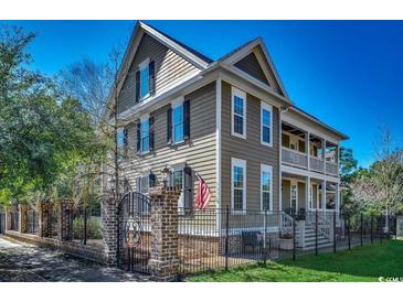 Charming two-story home with a landscaped yard, wrought iron fence, and inviting front porch at 1539 Old Town Ave., Georgetown, SC 29440