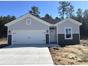 Charming single-Gathering home featuring a two-car garage, light gray siding and well-maintained landscaping at 264 Palmetto Sand Loop, Conway, SC 29527