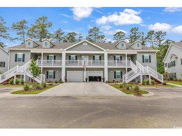 Charming townhome with dual staircases and a shared driveway leading to attached garages at 940 Jackline Place # 202, Murrells Inlet, SC 29576