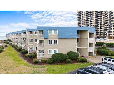 Beachfront condo with blue trim, multiple balconies, and manicured landscaping at 9660 Shore Dr. # 117, Myrtle Beach, SC 29572