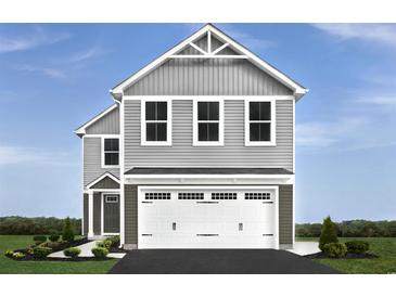 Charming two-story home with gray siding and a two-car garage beneath the main structure at 1174 Oak Meadow Dr., Conway, SC 29526