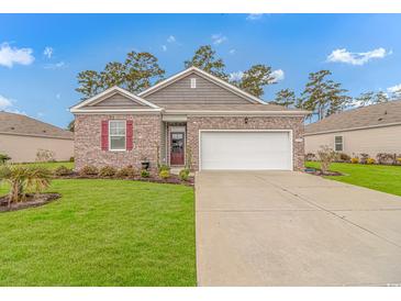 Charming single-story brick home with manicured lawn and two-car garage under a bright, sunny sky at 1119 Maxwell Dr., Little River, SC 29566