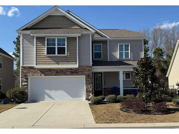Charming two-story home with a two-car garage, stone accents, and a well-manicured front yard at 204 Juniata Loop, Little River, SC 29566