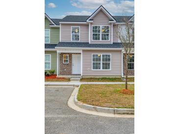 Charming two-story townhome with beige siding, brick accents, and a well-manicured lawn at 2705 Mercer Dr. # 2705, Conway, SC 29526