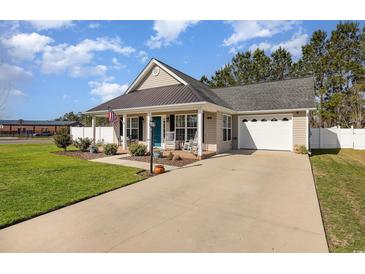 Charming one-story home with a well-maintained lawn, inviting porch with rocking chairs, and an attached two-car garage at 115 Blue Pride Dr., Loris, SC 29569