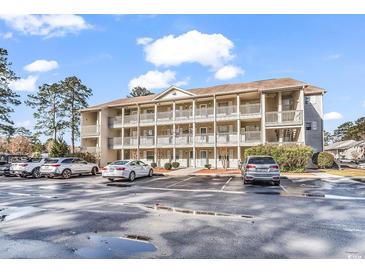 Exterior shot of condominiums with multiple levels and balconies, surrounded by well-maintained landscaping and parking at 1230 St. George Ln. # F, Myrtle Beach, SC 29588