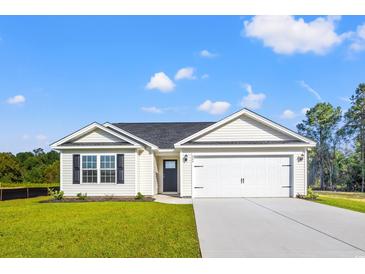 Charming single-story home featuring a two-car garage, manicured lawn, and classic vinyl siding at 411 Lifestyle Court, Surfside Beach, SC 29575