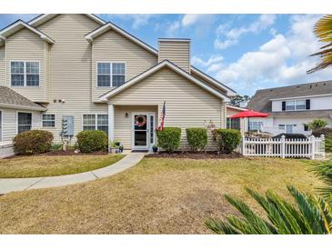 Inviting townhome featuring charming entrance with sidewalk, manicured landscaping, and a decorative wreath on the front door at 119 Gully Branch Dr. # 4, Myrtle Beach, SC 29572