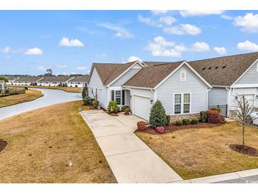 Inviting one-story home featuring a well-maintained lawn and attached two-car garage, near a tranquil waterway at 725 Salerno Circle # A, Myrtle Beach, SC 29579