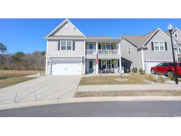 Charming two-story home featuring a quaint front porch, well-maintained landscaping, and a two-car garage at 780 Old Murrells Inlet Rd., Murrells Inlet, SC 29576