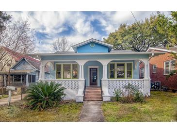 Charming blue house with a welcoming front porch and beautifully landscaped front yard at 1019 Prince St., Georgetown, SC 29440