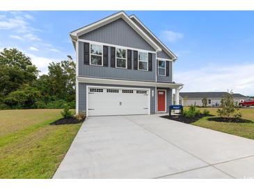Charming two-story home featuring a spacious two-car garage, red door, and manicured lawn at 1108 Oak Meadow Dr., Conway, SC 29526
