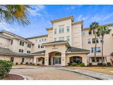 Elegant condominium complex featuring a stone paved driveway and coastal landscaping under a bright sky at 2180 Waterview Dr. # 713, North Myrtle Beach, SC 29582