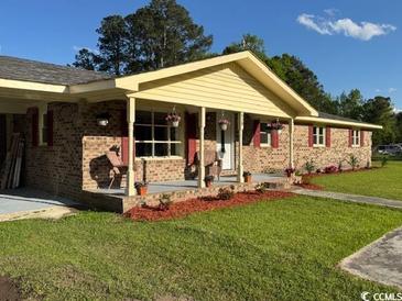 Charming single story brick home with well manicured lawn and quaint covered front porch at 538 Oatland Rd., Georgetown, SC 29440