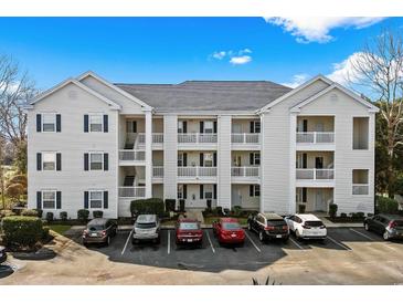 A view of the condo's exterior with white siding and parking in front under a blue sky at 901 West Port Dr. # 1611, North Myrtle Beach, SC 29582