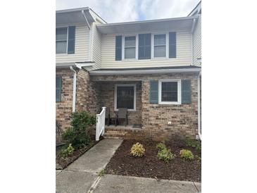 Charming townhome facade featuring brick exterior, blue shutters, and a welcoming porch at 210 25Th Ave. S # 26, Myrtle Beach, SC 29577