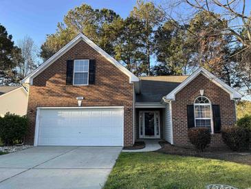 Charming brick home featuring an attached garage and well-maintained lawn at 280 Barclay Dr., Myrtle Beach, SC 29579