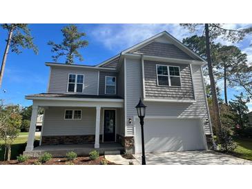Charming two-story home with a covered front porch, attached garage, and stone accents at 422 Clear Lake Dr., Conway, SC 29526