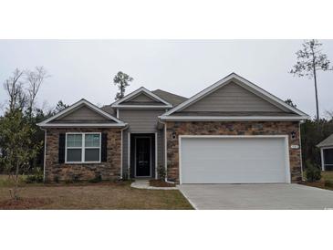 Charming single-story home with stone and siding, complemented by a two-car garage and well-manicured landscaping at 423 Clear Lake Dr., Conway, SC 29526