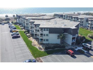 An aerial view of a multi-story condo building with parking and ocean views at 5601 N Ocean Blvd. # B306, Myrtle Beach, SC 29577