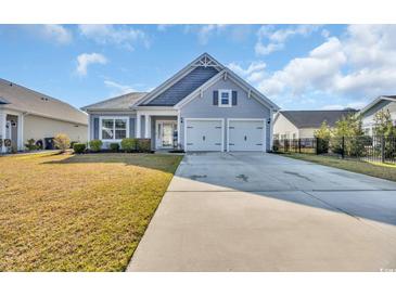 Charming single-story home featuring a two-car garage and well-manicured lawn on a sunny day at 804 Yauhannah Dr., Little River, SC 29566