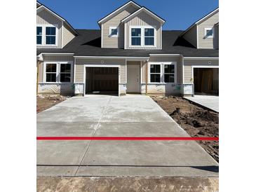 New construction townhomes with garages and concrete driveways offer modern living at 2042 Wild Indigo Circle Nw # 204, Calabash, NC 28467