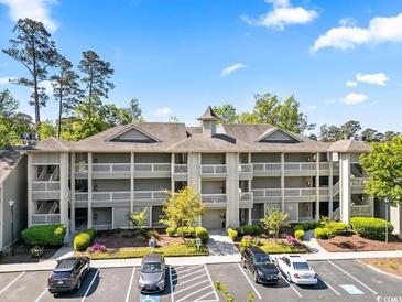 A condo building featuring balconies, a well-maintained landscape and ample parking space for residents and visitors at 1551 Spinnaker Dr. # 5821, North Myrtle Beach, SC 29582