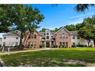 Charming condo exterior with brick facade, green lawn, and mature trees on a sunny day at 4305 Lotus Ct. # G, Murrells Inlet, SC 29576