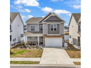 Charming two-story home with a well-maintained yard and a two-car garage at 511 Mcalister Dr., Little River, SC 29566
