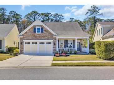 Charming home featuring a stone facade, a well-manicured lawn, and an attached two-car garage at 1309 Suncrest Dr., Myrtle Beach, SC 29577
