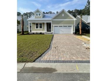 Charming one-story home with a two-car garage, manicured lawn, and brick paver driveway at 382 Waties Dr., Murrells Inlet, SC 29576